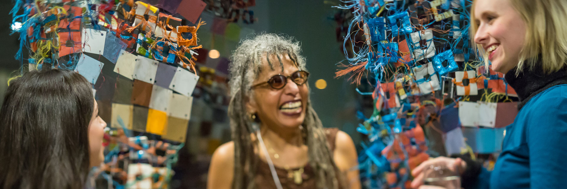 Artist Marita Dingus talks with BIMA members in front of her work at a Member Party.