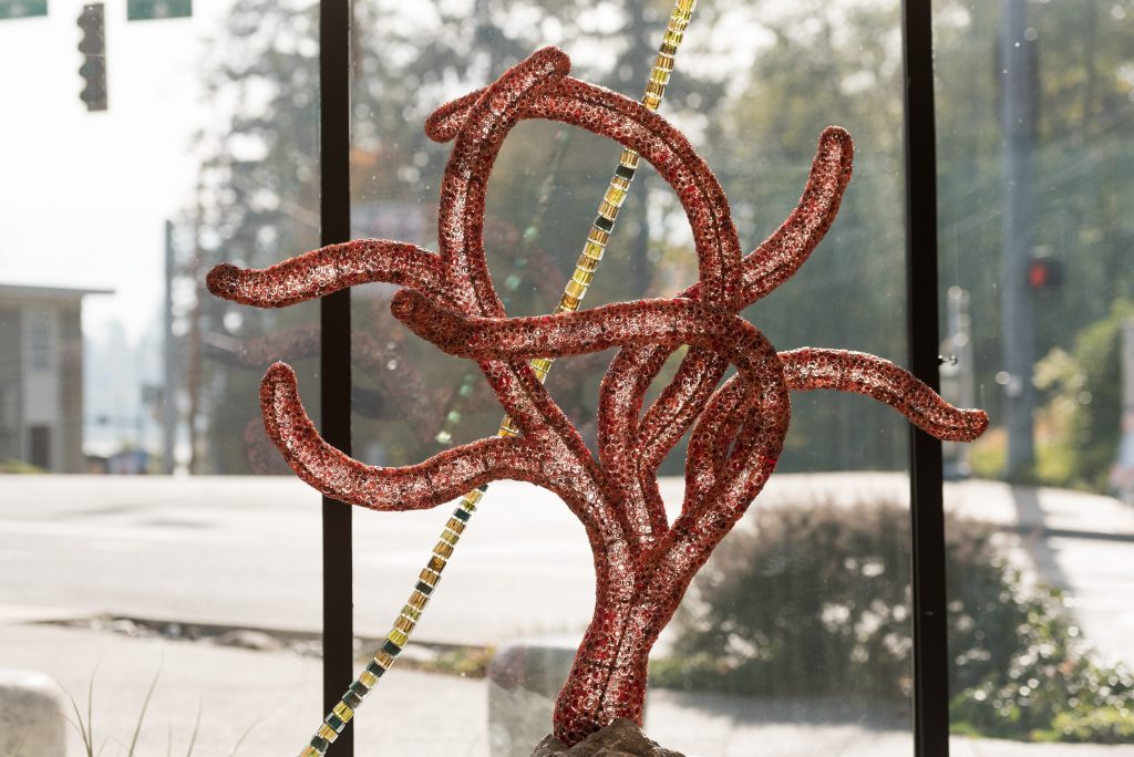 Kait Rhoads, Red Polyp, 2007, blown glass, mixed red hollow murrine woven with copper wire onto a powder coated steel frame set on a solid steel base, 45" high x 46" wide x 19" deep.
