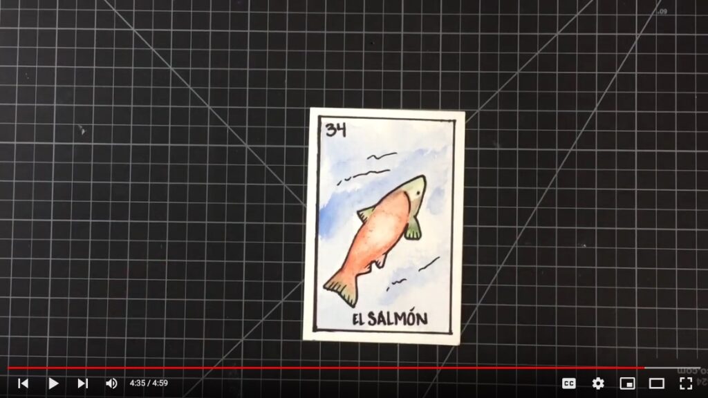 A hand-drawn salmon Lotería card on a cutting mat