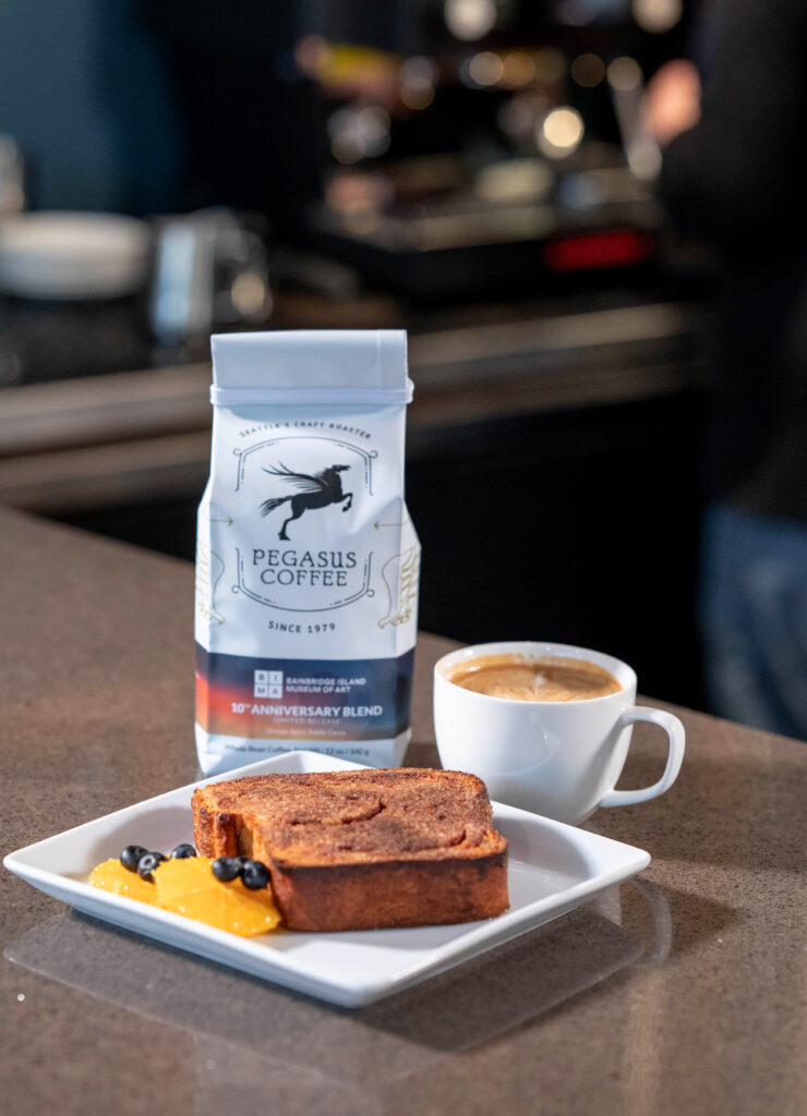 Cinnamon Toast, a pound of Pegasus Coffee, and cup of coffee sit on the counter in the BIMA Bistro