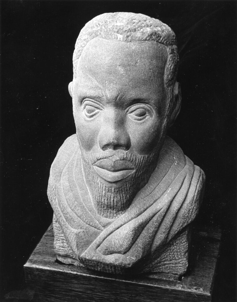 Stone bust of a bearded man with a serious expression and draped garment, carved in a realistic style.