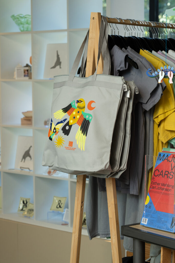 A grey bag with a block colored bird and moon