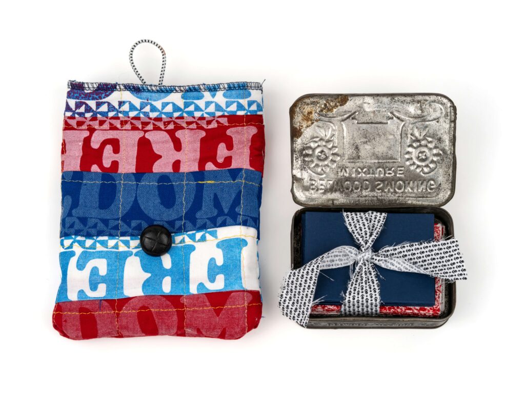 On the left red white and blue fabric that says freedom  on the left in a tin with fabric inside