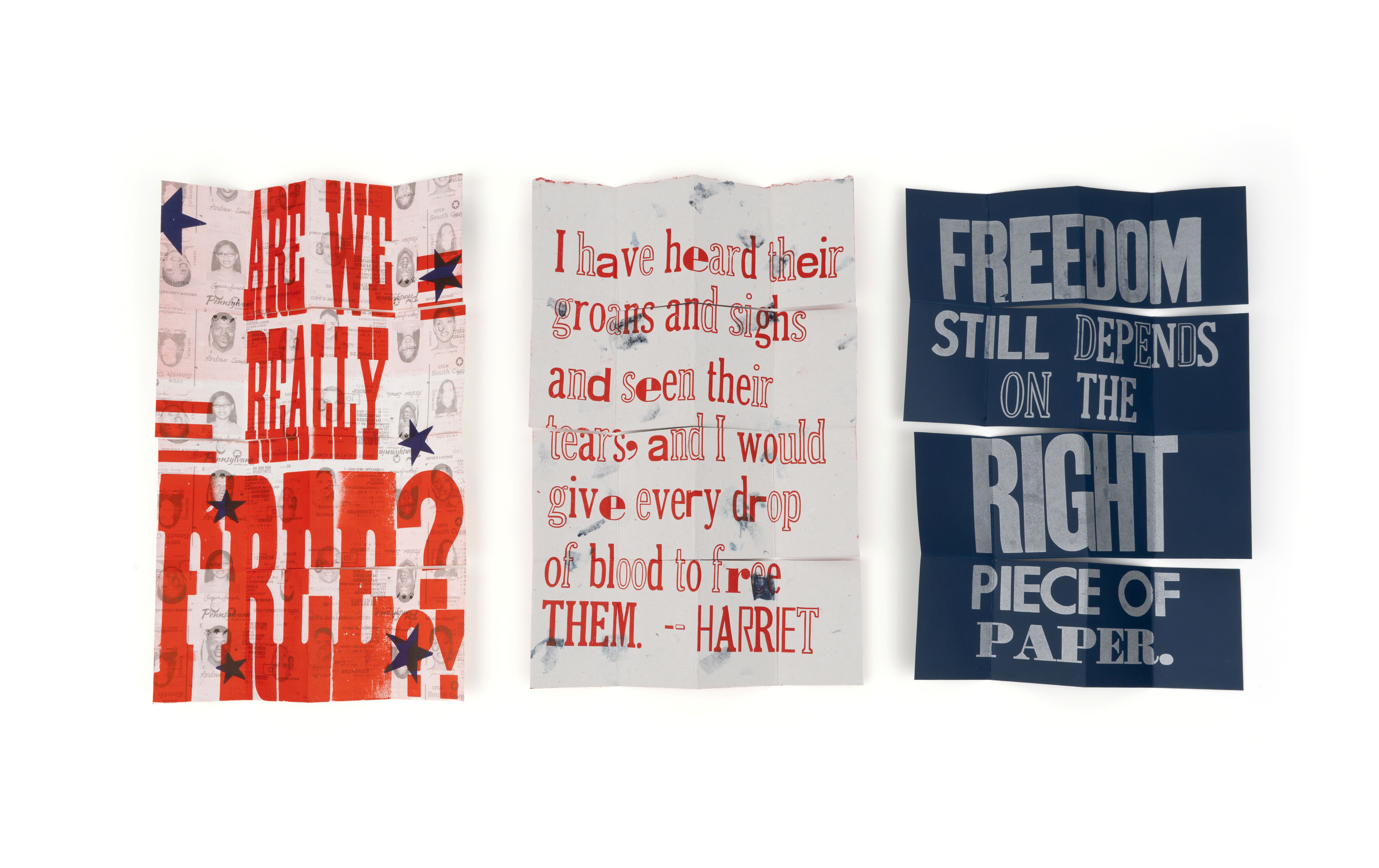 Three pieces of fabric, two are white and one is navy blue, with red and grey text printed on them.